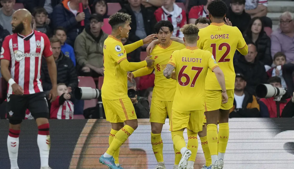 <p>Penyerang Liverpool, Takumi Minamino (tengah) berselebrasi dengan rekan setimnya usai mencetak gol ke gawang Southampton pada pertandingan lanjutan Liga Inggris di Stadion St. Mary di Southampton, Inggris, Rabu (18/5/2022). Liverpool menang tipis atas Southampton 2-1. (AP Photo/Frank Augstein)</p>