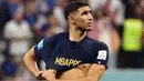 Pemain Maroko, Achraf Hakimi mengenakan baju milik pemain Prancis, Kylian Mbappe berjalan meninggalkan lapangan setelah laga semifinal Piala Dunia 2022 yang berlangsung di Al Bayt Stadium, Qatar, Rabu (14/12/2022) waktu setempat. Prancis menang dengan skor 2-0 melalui gol Theo Hernandez dan Randal Kolo Muani. (AFP/Karim Jaafar)