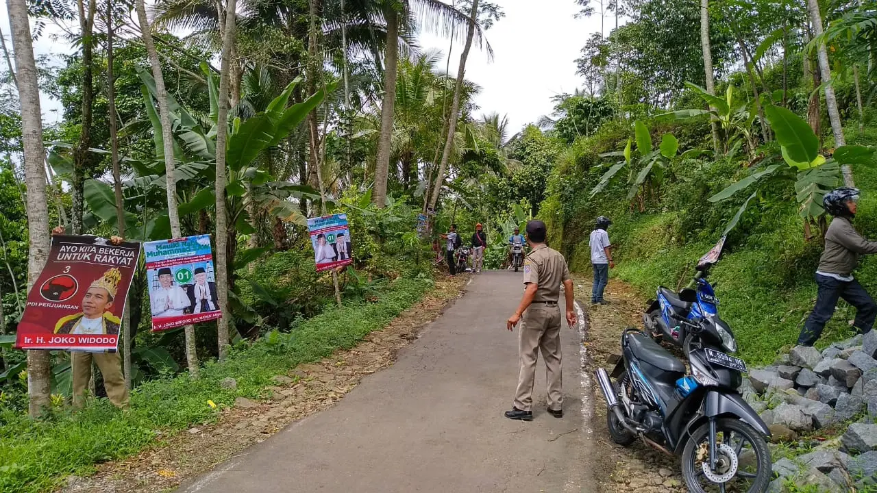 Petugas mencopot APK yang melanggar aturan pemasangan. Di antaranya, poster Jokowi bermahkota alias Jokowi raja. (Liputan6.com/Panwas Banyumas/Muhamad Ridlo)