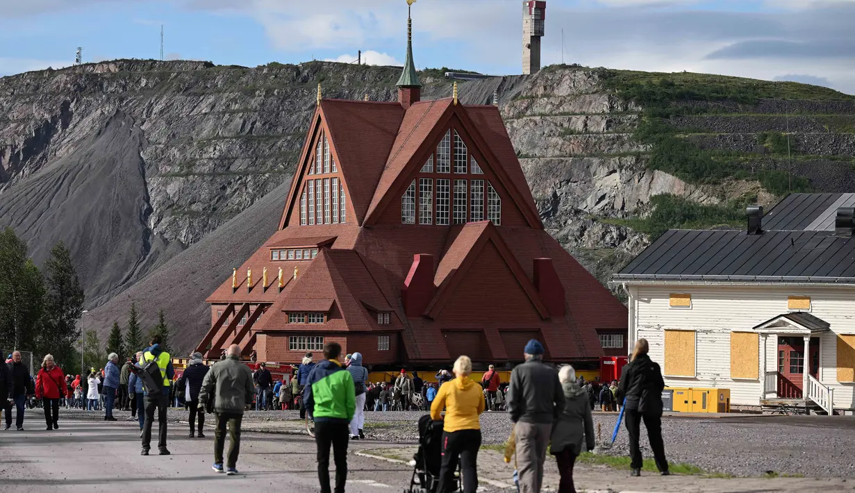 Struktur kayu merah raksasa gereja Kiruna yang dibangun pada tahun 1912 telah diangkat ke atas trailer raksasa dan sedang dalam perjalanan menuju pusat kota baru. (Jonathan Nackstrand/AFP)