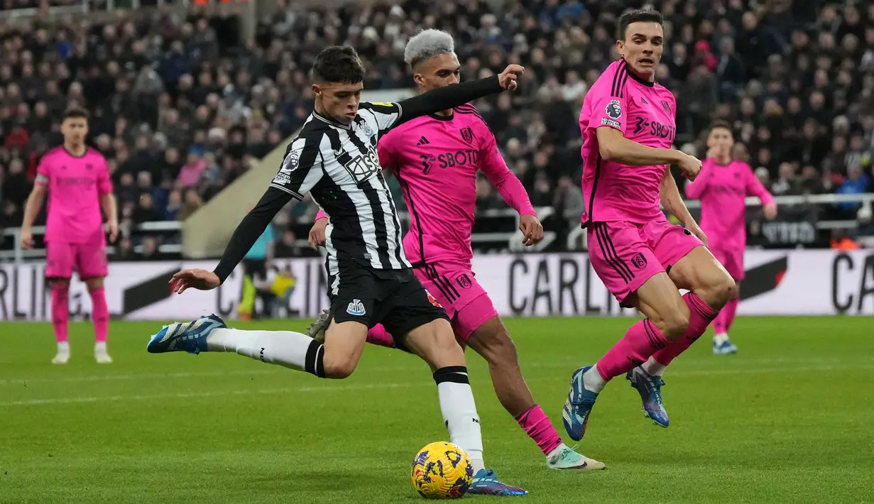 Gelandang Newcastle United, Lewis Miley (kiri) melepaskan tendangan yang menghasilkan gol pertama timnya ke gawang Fulham pada laga pekan ke-17 Liga Inggris 2023/2024 di St James' Park, Newcastle, Sabtu (16/12/2023). (AFP/Andy Buchanan)