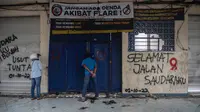 Orang-orang melihat ke dalam Stadion Kanjuruhan pada 3 Oktober 2022, beberapa hari setelah tragedi mengenaskan usai pertandingan antara Arema FC melawan Persebaya Surabaya. Setidaknya 125 orang tewas ketika penggemar tuan rumah yang marah menyerbu lapangan dan polisi menanggapi dengan gas air mata yang memicu desak-desakan. (AFP/Juni Kriswanto)
