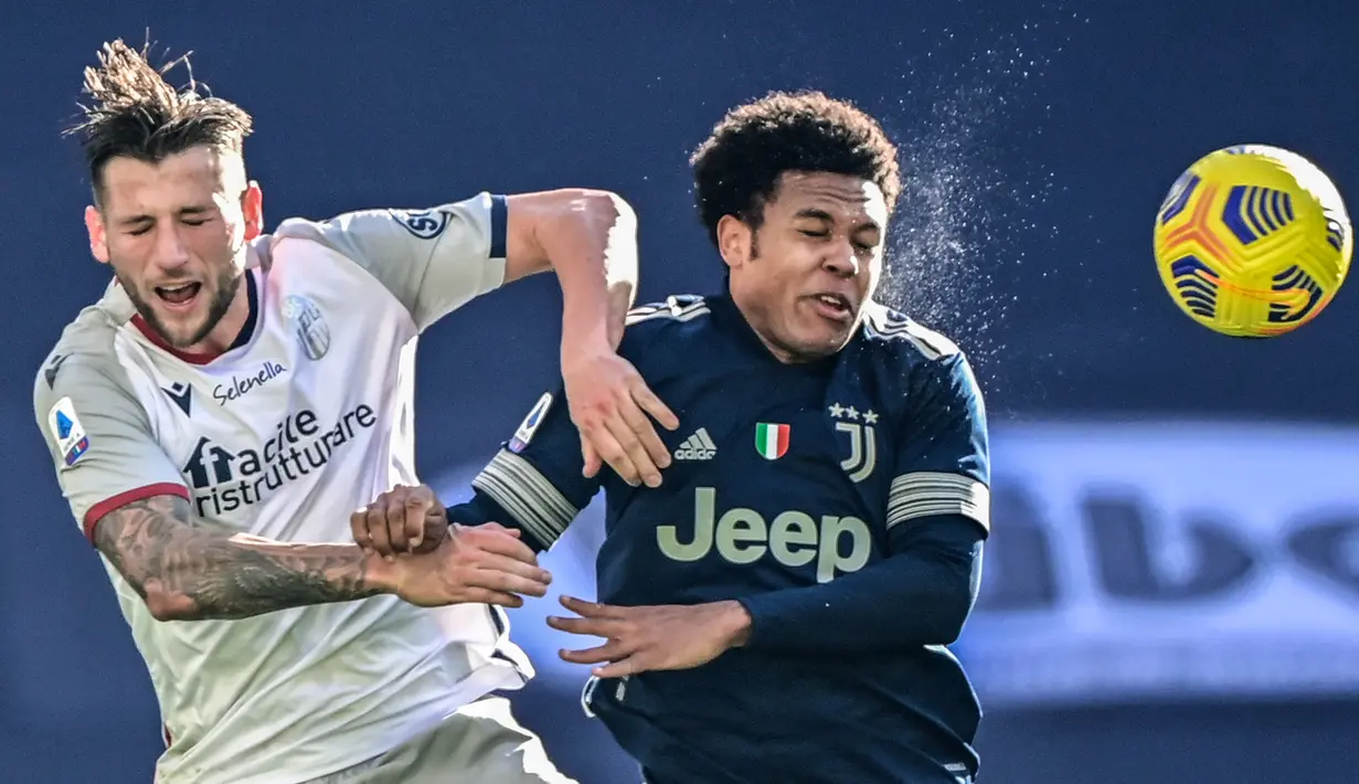 Duel udara pemain Juventus, Weston McKennie (kanan) dengan pemain Bologna, Mitchell Dijks dalam laga lanjutan Liga Italia di Stadion Allianz, Turin, Minggu (24/1/2021). (Foto: AFP/Miguel Medina)