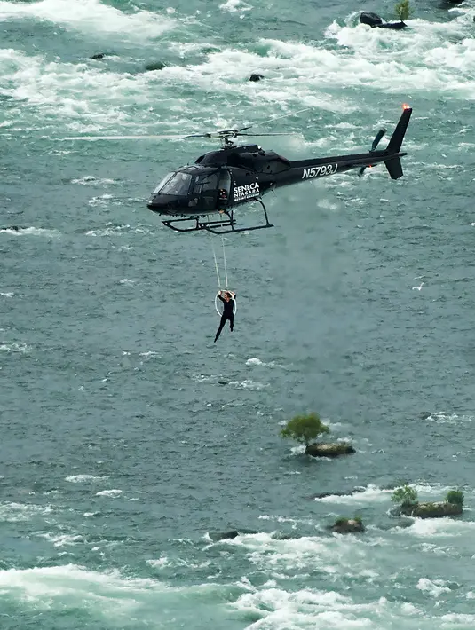 Erendira Wallenda melakukan aksi akrobatik di atas air terjun Niagara, New York, Kamis (15/6). Erendira ditambatkan ke lingkaran besi yang dikaitkan pada helikopter yang terbang 91 meter di atas permukaan air. (Nathan Denette/The Canadian Press via AP)