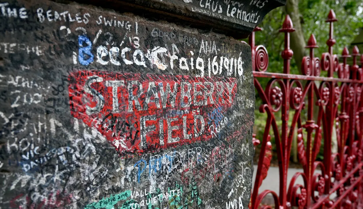 Graffiti digambarkan di gerbang Strawberry Field yang baru dibuka untuk umum di Liverpool, Rabu (18/9/2019). Strawberry Field adalah nama sebuah panti Salvation Army di sekitar sudut rumah masa kecil John Lennon yang menjadi populer dan kini dibuka untuk umum usai 70 tahun ditutup. (Paul ELLIS/AFP)