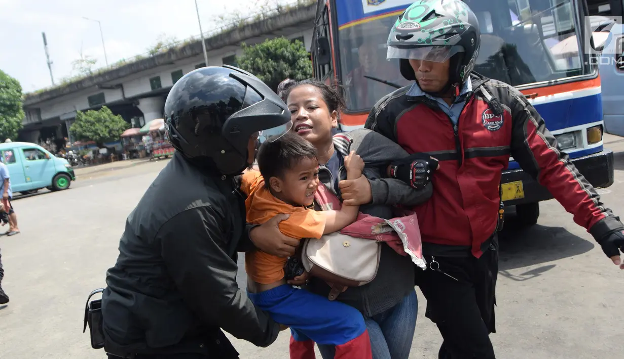 Seorang wanita dan anaknya terjaring razia oleh petugas Dinsos DKI di Kawasan Terminal Kampung Melayu, Jakarta, Jumat (11/5). Razia dilakukan dalam rangka jelang bulan Ramadan. (Liputan6.com/Arya Manggala)