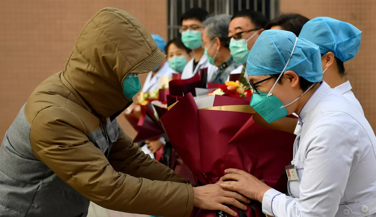 Pasien yang dinyatakan sembuh dari virus corona memberi salam perpisahan kepada petugas medis di Rumah Sakit Afiliasi Pertama Universitas Zhengzhou, Provinsi Henan, China, Selasa (4/2/2020). Ini adalah pasien pertama yang dinyatakan sembuh dari virus corona di Shaanxi. (Xinhua/Liu Xiao)