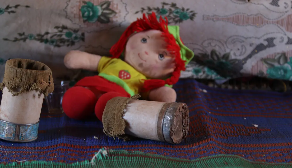 Kaki prostetik dari kaleng milik Maya Mohammad Ali Merhi (8) tergeletak samping boneka di sebuah kamp orang terlantar di Provinsi Idlib, Suriah, Rabu (20/6). (Aaref Watad/AFP)