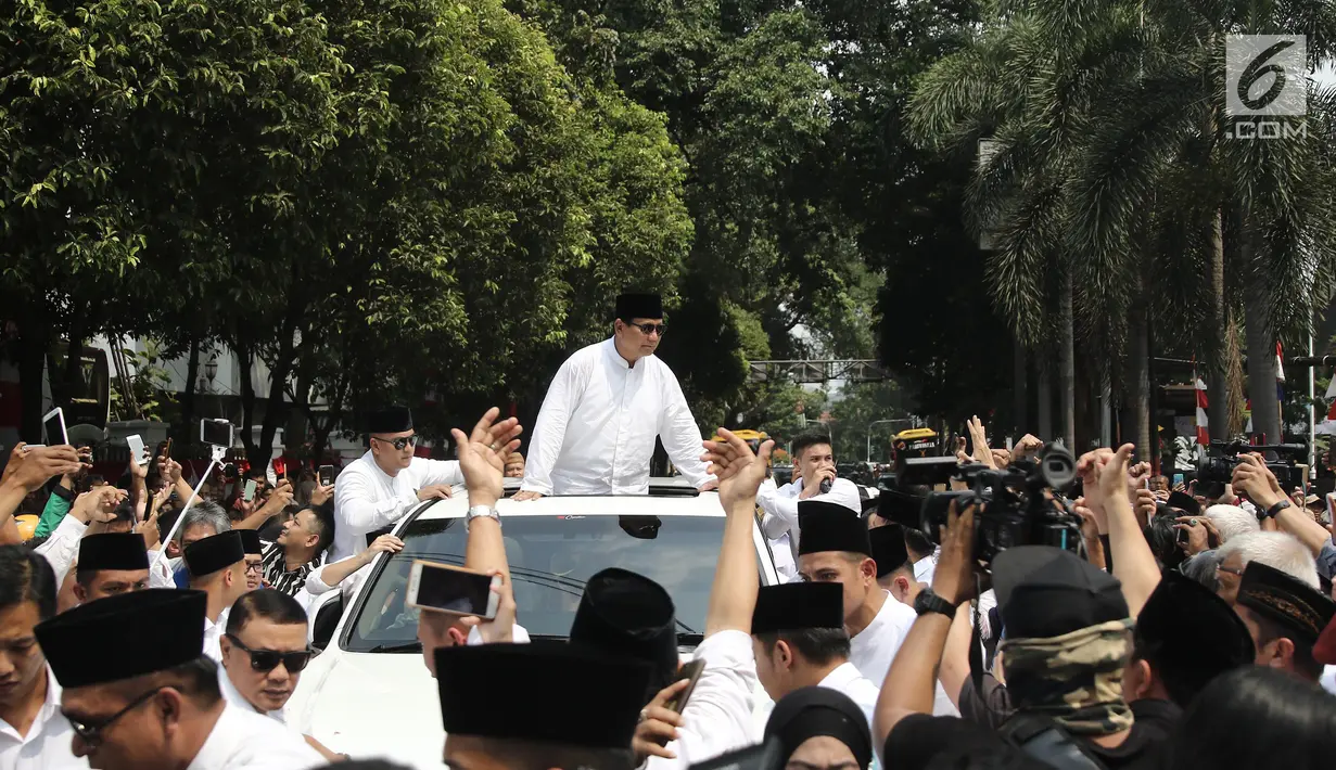 Bakal Calon Presiden, Prabowo Subianto berdiri di atas mobilnya dalam perjalanan menuju Gedung KPU RI, Jakarta, Jumat (10/8). Ketua Umum Gerindra Prabowo Subianto berangkat ke KPU untuk mendaftarkan diri sebagai capres. (Liputan6.com/Herman Zakharia)