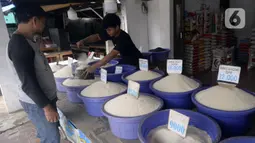 Pedagang beras melayani pembeli di pinggir Jalan Raya Pamulang, Tangerang Selatan, Banten, Jumat (11/12/2020). Jelang Natal dan Tahun Baru 2021, harga beras dipasaran masih normal tidak ada kenaikan. (merdeka.com/Dwi Narwoko)