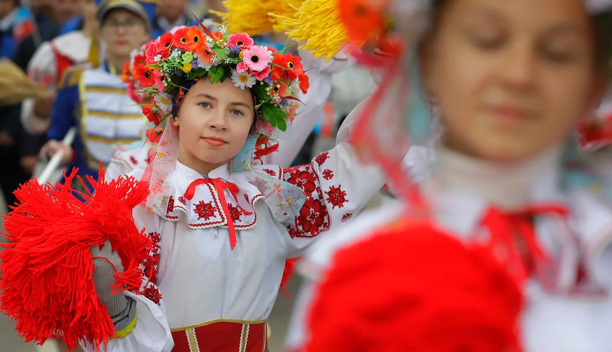 Seorang anak perempuan dalam balutan baju adat di Festival Dozynki, Minsk, Belarusia, Minggu (7/10). Dozynki dirayakan dengan berbagai variasi di setiap negara Eropa. Waktunya pun disesuaikan dengan masing-masing negara. (AP Photo/Sergei Grits)