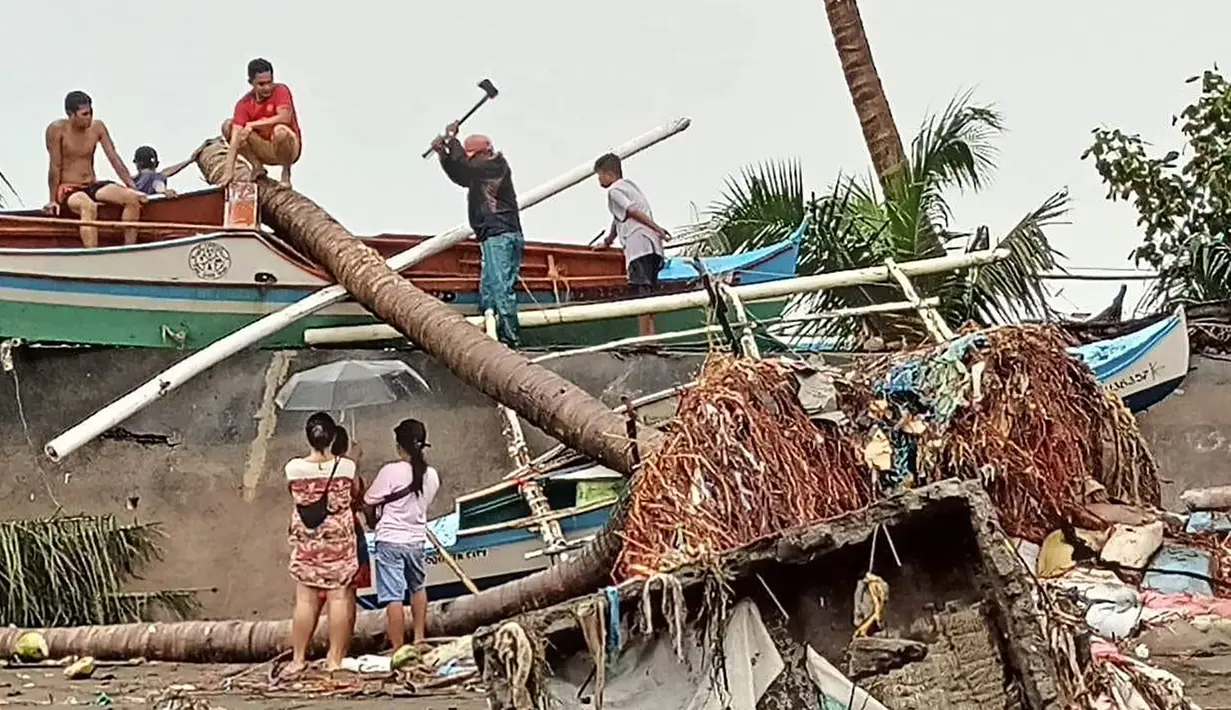 Penduduk mengecek kerusakan akibat hujan lebat dan banjir di Kota Oroquieta, Misamis Occidental (27/12/2022). Korban tewas akibat banjir di Filipina telah meningkat menjadi 25 orang, kata para pejabat pada 28 Desember, dengan badai diperkirakan akan menurunkan lebih banyak hujan di wilayah selatan dan tengah yang paling terpukul. (Photo by Handout/Angelica Villarta/AFP)