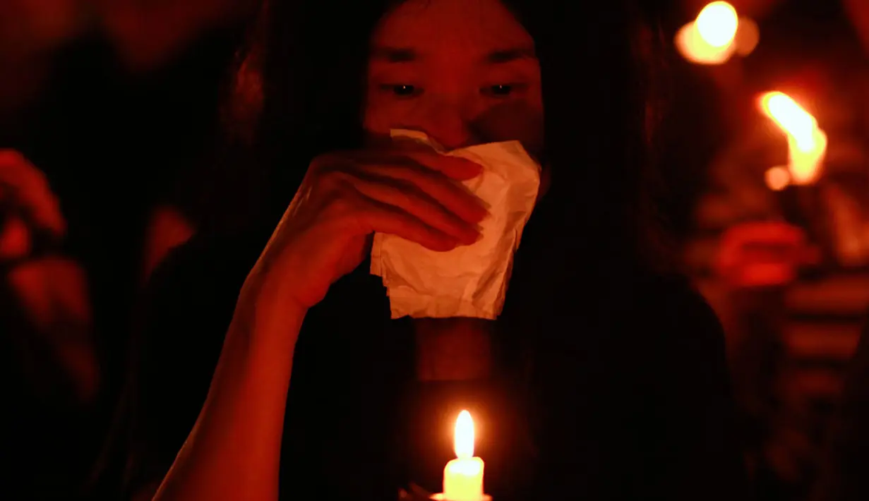 Isak tangis mewarnai upacara peringatan 25 tahun tragedi penumpasan gerakan pro demokrasi oleh militer Tiongkok. Tampak salah satu peserta menangis saat menyalakan lilin di Victoria Park, Hong Kong, (4/6/2014). (REUTERS/Bobby Yip) 