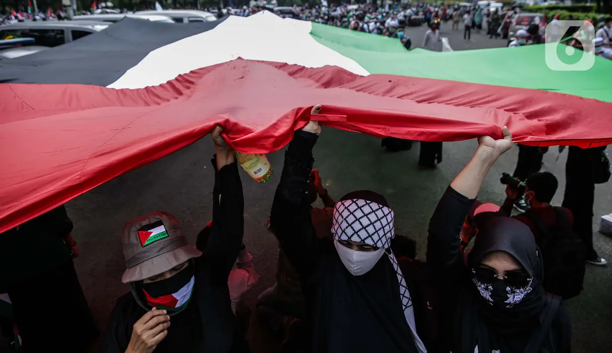 Pengunjuk rasa membentangkan bendera Palestina di depan Kedubes Amerika Serikat, Jumat (21/5/2021). Aksi yang diikuti berbagai elemen masyarakat dan ormas itu mengutuk serangan Israel dan mengajak masyarakat Indonesia untuk mendukung dan membantu Palestina. (Liputan6.com/Faizal Fanani)