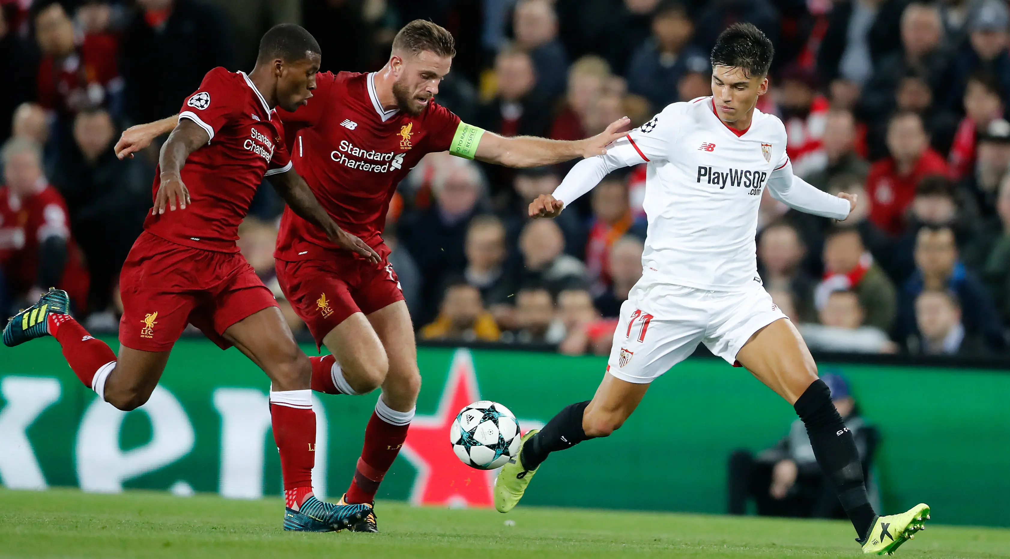 Pemain Sevilla, Joaquin Correa berusaaa merebut bola dari pemain Liverpool, Joe Gomez dan Jordan Henderson pada laga Grup E Liga Champions di Stadion Anfield, Rabu (13/9). Sevilla berhasil menahan imbang Liverpool dengan skor 2-2 (AP Photo/Frank Augstein)