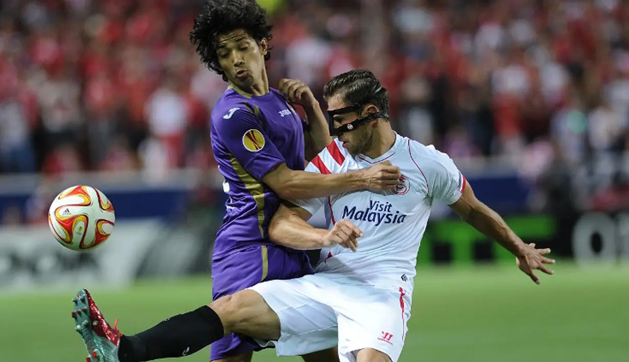 Gelandang Sevilla, Grzegorz Krychowiak (kanan) berebut bola dengan gelandang Matias Fernandez pada leg pertama semifinal Europa League di Stadion Ramon Sanchez, Kamis (7/5/2015). Sevilla menang 3-0 atas Fiorentina. (AFP PHOTO/Cristina Quicler)