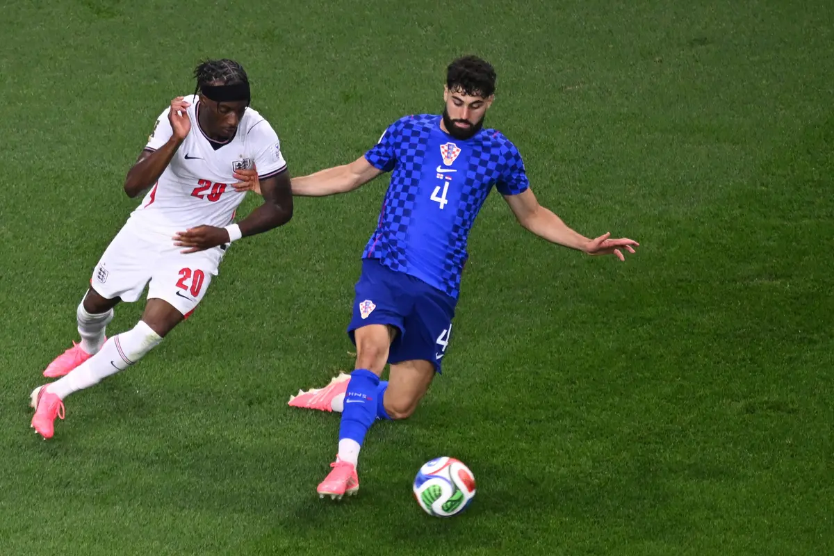 Pemain Kroasia Josko Gvardiol (kanan) berebut bola dengan pemain Inggris Noni Madueke (kiri)