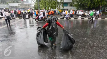  Seorang petugas kebersihan DKI Jakarta membawa sampah usai aksi damai 2 Desember di kawasan Jalan MH Thamrin, Jakarta, Jumat (2/12). Aksi damai 2 Desember digelar sebagai lanjutan dari aksi 4 November 2016. (Liputan6.com/Ferbian Pradolo)