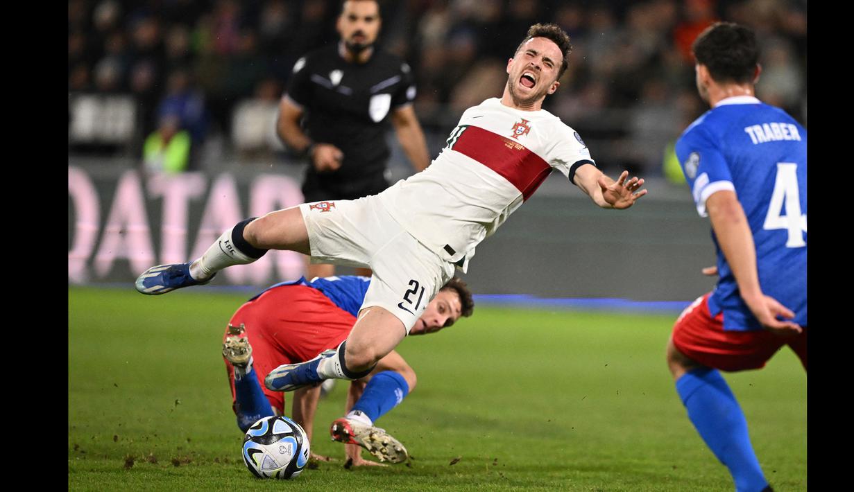 Striker Timnas Portugal, Diogo Jota mengerang kesakitan setelah ditekel gelandang Liechtenstein, Simon Luchinger pada laga lanjutan Grup J Kualifikasi Euro 2024 di Rheinpark Stadium, Vaduz, Jumat (17/11/2023) dini hari WIB. (AFP/Sebastien Bozon)