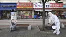 Pekerja mendisinfeksi jalan di Goyang, Korea Selatan, Selasa (25/8/2020). Korea Selatan menutup sekolah dan beralih kembali ke pembelajaran jarak jauh setelah memasuki hari ke-12 peningkatan berturut-turut dalam kasus COVID-19. (AP Photo/Ahn Young-joon)