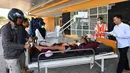 Seorang anak korban gempa Lombok mendapat perawatan medis di luar Rumah sakit Moh. Ruslan di Mataram,  Senin (6/8). Berdasarkan laporan sementara yang diterima BPBD NTB, korban meninggal akibat gempa Lombok sudah mencapai 89 orang. (AFP/ADEK BERRY)