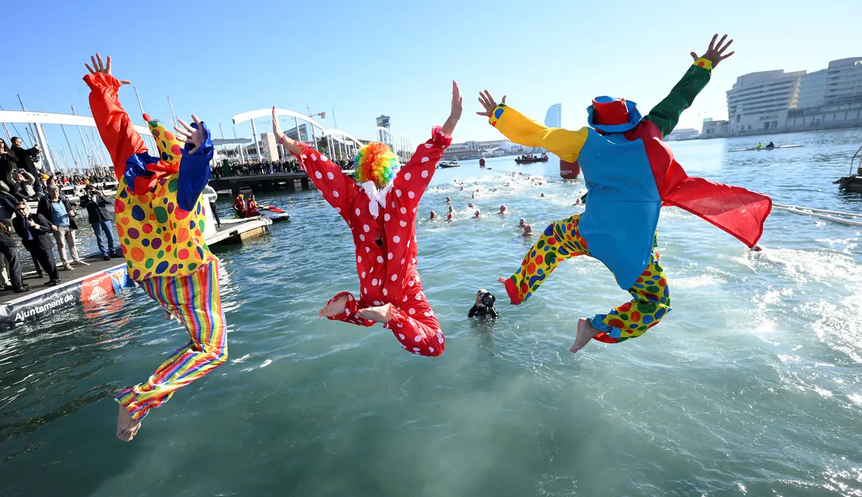 Para peserta menceburkan diri ketika mengikuti lomba renang unik saat natal di pelabuhan tua Barcelona (Port Vell Barcelona), Spanyol, Senin (25/12/2023) waktu setempat. (AFP/Josep Lago)