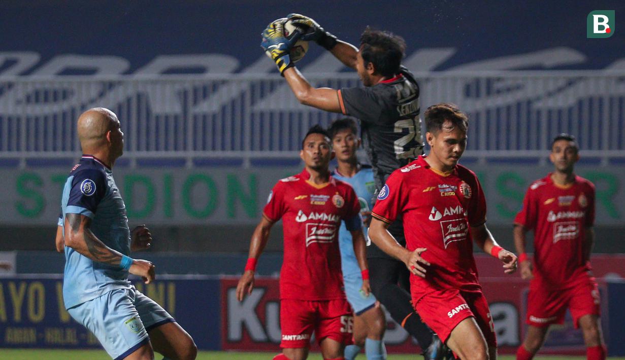 Kiper Persija Jakarta, Adixi Lenzivio (atas) menangkap bola saat melawan Persela Lamongan dalam laga pekan ke-4 BRI Liga 1 2021/2022 di Stadion Pakansari, Bogor, Jumat (24/09/2021). Persija menang 2-1. (Bola.com/Bagaskara Lazuardi)