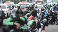 Pengemudi ojek online (ojol) memenuhi bahu jalan saat menunggu penumpang di kawasan Cililitan, Jakarta, Rabu (16/9/2020). Pemprov DKI Jakarta telah melarang ojol dan ojek pangkalan berkumpul lebih dari lima orang serta menjaga jarak sepeda motor minimal dua meter. (merdeka.com/Iqbal S. Nugroho)