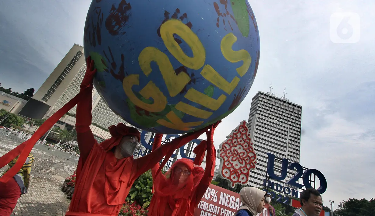 Aktivis lingkungan dari Extinction Rebellion Indonesia melakukan aksi penanganan mitigasi krisis iklim di Bundaran HI, Jakarta, Minggu (13/11/2022). Aktivis menuntut kepedulian negara-negara peserta KTT G20 untuk melakukan transisi energi yang berkelanjutan dan berkeadilan dalam krisis iklim. (merdeka.com/Arie Basuki)