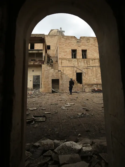 Tentara Irak mengamati kondisi Gereja St. George Monastery (Mar Guguis) yang rusak parah di Mosul, 22 Januari 2017. Salah satu gereja bersejarah di Irak tersebut tak luput dari pengerusakan yang dilakukan kelompok radikal ISIS. (AHMAD AL-RUBAYE/AFP)