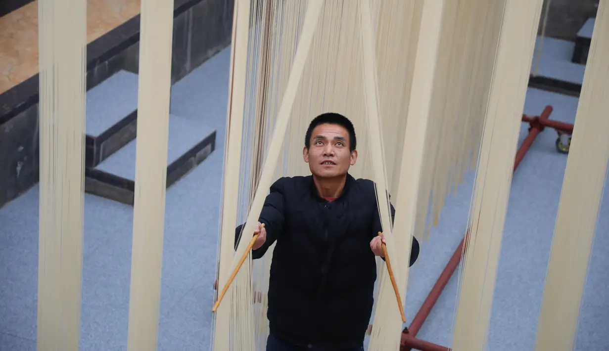 Penduduk desa mengeringkan mi di Desa Huangjiazhuang di Distrik Maiji, Kota Tianshui, Provinsi Gansu, China pada 30 November 2020. Mi buatan desa itu tidak hanya populer di kalangan penduduk setempat, tetapi juga laris terjual ke seluruh penjuru China melalui platform e-commerce. (Xinhua/Ma Xiping)