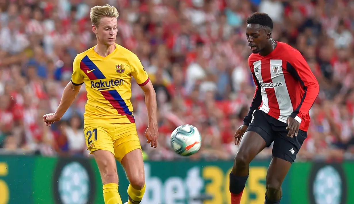 Striker Athletic Bilbao, Inaki Williams (kanan) membawa bola dari kejaran gelandang Barcelona, Frenkie de Jong  selama pertandingan perdana La Liga Spanyol di Stadion San Mames, Sabtu (17/8/2019). Bilbao menang tipis atas Barcelona dengan skor 1-0. (AFP Photo/Ander Gillenea)