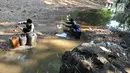Warga mengambil air dari lubang pada aliran Sungai Cihoe untuk memenuhi kebutuhan sehari-hari termasuk air minum di kawasan Ridogalih, Cibarusah, Bekasi, Minggu (7/7/2019). Sudah lebih dari dua bulan, warga memanfaatkan sisa aliran sungai yang kotor akibat musim kemarau. (merdeka.com/Arie Basuki)