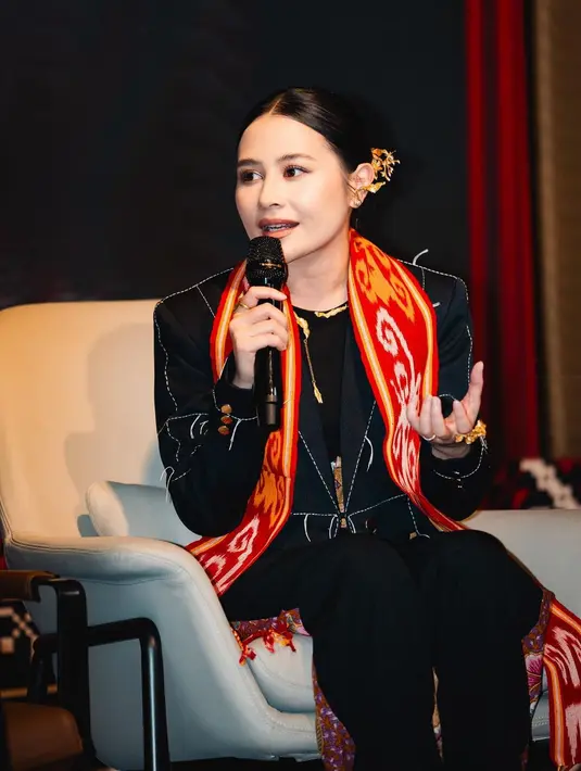 Atau ketika Prilly mengenakan outfit serba hitam dengan sentuhan syal dari tenun berwarna merah yang dikalungkan di lehernya. [Foto: Instagram/prillylatuconsina96]