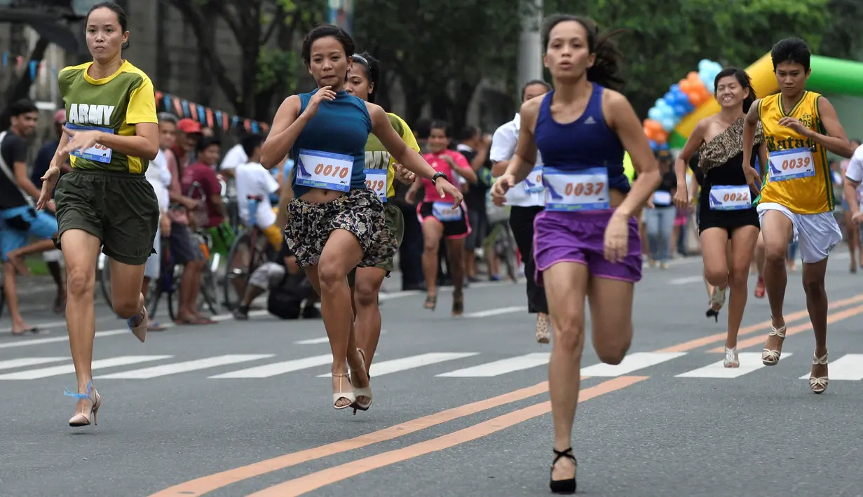 Peserta berlari menggunakan sepatu high heels saat acara"Tour De Takong" di Marikina, Manila, Filipina, 26 November 2016. Balap lari itu merupakan bagian dari festival sepatu tahunan di wilayah yang dikenal sebagai ibu kota sepatu. (REUTERS/Ezra Acayan)