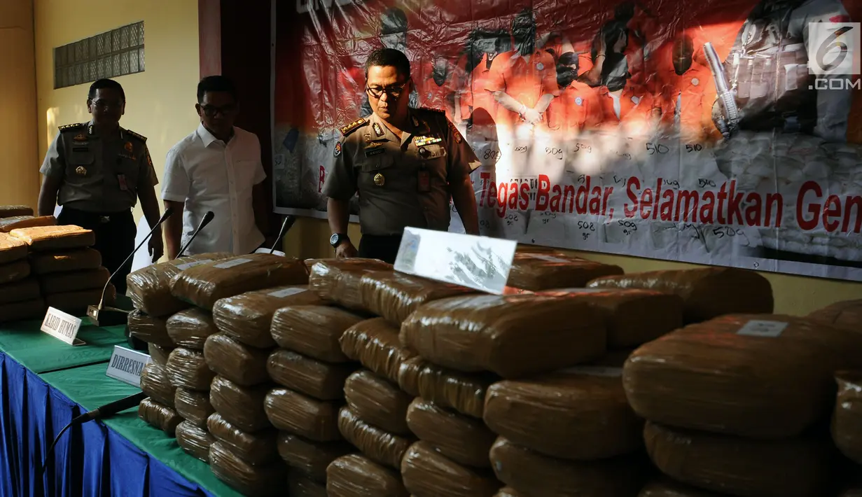 Kabid Humas Polda Metro Jaya Kombes Pol Argo Yuwono melihat barang bukti 225 kg ganja saat rilis di RS Polri Kramat Jati Jakarta, Rabu (30/8). Satresnarkoba Polda Metro Jaya menggagalkan peredaran 225 kg ganja asal Aceh. (Liputan6.com/Helmi Fithriansyah)