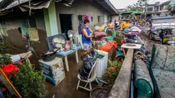 Warga menyelamatkan harta benda usai hujan deras yang dibawa Topan Goni memicu terjadinya banjir di Provinsi Batangas, Filipina, 2 November 2020. Hingga 2 November 2020, jumlah korban jiwa akibat Topan Goni yang melanda bagian selatan Luzon bertambah menjadi 16 orang. (Xinhua/Rouelle Umali)