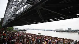 Ratusan umat Hindu berkumpul untuk mengikuti ritual 'Tarpan' untuk mempersembahkan doa kepada leluhur mereka pada hari terakhir Pitrupaksh di tepian Sungai Gangga di Kolkata (19/9). (AFP Photo/Dibyangshu Sarkar)