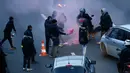 Seorang sopir taksi memegang suar api sambil memblokir jalan saat unjuk rasa menentang layanan transportasi VTC seperti Uber, di jalan lingkar di porte Maillot di Paris, Perancis, Selasa (26/1). (AFP PHOTO/Thomas SAMSON)