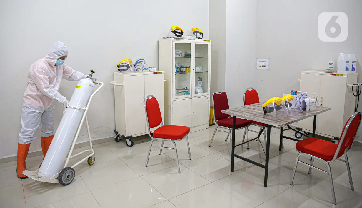 Petugas mengenakan hazmat saat menyiapkan tabung oksigen di Tower 8 Wisma Atlet Pademangan, Jakarta, Selasa (15/6/2021). Tower 8 Wisma Atlet Pademangan bisa menampung 1.569 pasien untuk isolasi. (Liputan6.com/Faizal Fanani)