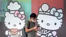 Seorang pria yang mengenakan masker berjalan melewati iklan Hello Kitty di luar sebuah toko serba ada di Kuala Lumpur, Malaysia, Senin (4/5/2020). Malaysia sejak lockdown sejatinya baru akan berakir pekan depan. (AP/Vincent Thian)