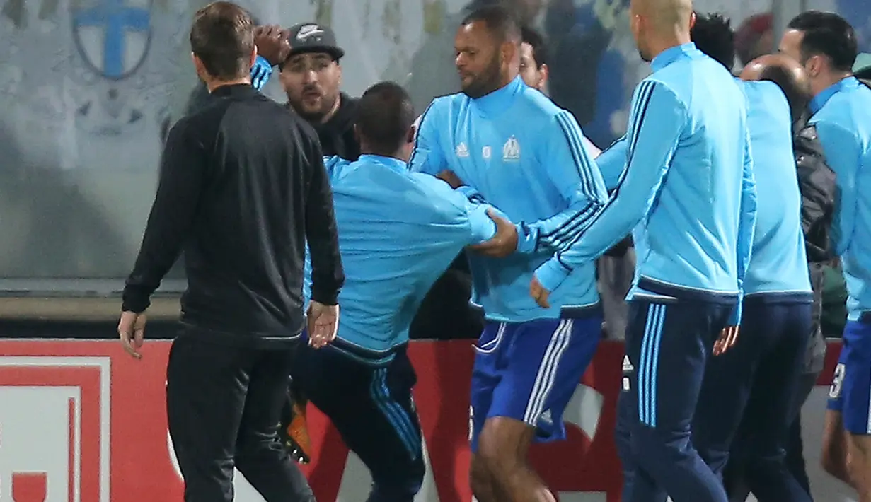 Bek Olympique Marseille, Patrice Evra menendang suporter menjelang partai Liga Europa lawan Vitoria Guimaraes di Estadio D. Afonso Henriques, Jumat (3/11). Evra menendang kepala suporter yang berada di balik papan iklan pinggir lapangan. (AP/Luis Vieira)