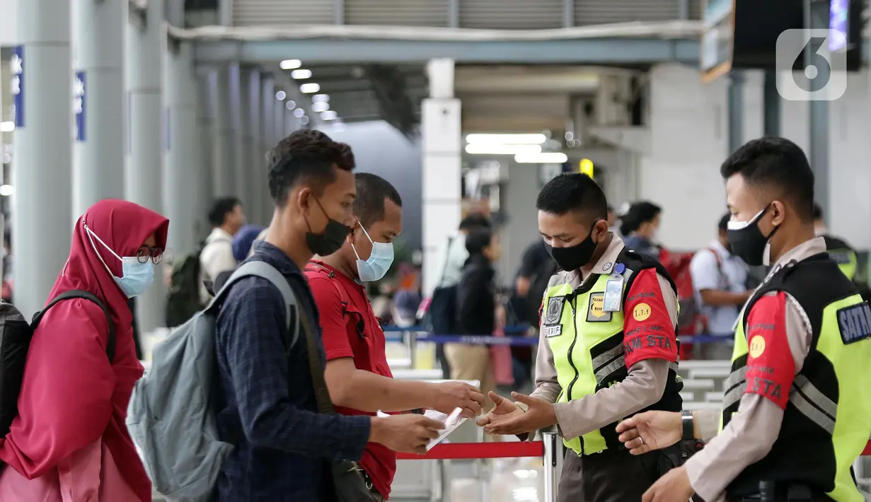 Petugas keamanan mengecek dokumen calon penumpang KA Jarak jauh, Stasiun Pasar Senen, Jakarta, Jumat (28/1/2022). Jelang libur Tahun Baru Imlek, jumlah penumpang di Stasiun Pasar Senen mengalami kenaikan 8.598 orang dibanding Jumat (21/1) lalu sebanyak 7.402 orang. (Liputan6.com/Helmi Fithriansyah)