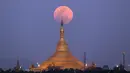 Pemandangan ketika supermoon terbit di belakang Pagoda Uppatasanti yang terlihat dari Naypyitaw, Myanmar, Rabu (31/1). (AP Photo / Aung Shine Oo)