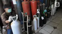 Pekerja mengisi ulang tabung gas oksigen di kawasan Ciputat, Tangerang Selatan, Banten, Senin (5/7/2021). Antrean terjadi seiring  peningkatan lonjakan korban positif COVID-19. (merdeka.com/Arie Basuki)