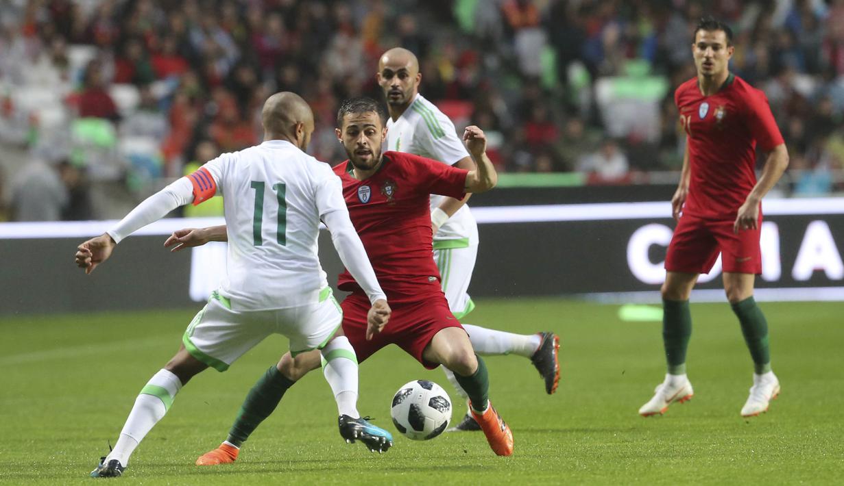 Striker Portugal, Bernardo Silva, berusaha melewati pemain Aljazair, Yacine Brahimi, pada laga uji coba di Estadio da Luz, Jumat (8/6/2018). Portugal menang 3-0 atas Aljazair. (AP/Armando Franca)