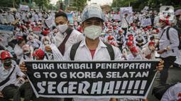 Massa calon pekerja migran Indonesia membawa poster memadati badan jalan Gatot Subroto, berunjuk rasa di depan kompleks Kemenaker, Jakarta, Senin (18/10/2021). Aksi dilakukan untuk menuntut kejelasan status penempatan mereka. (Liputan6.com/Faizal Fanani)
