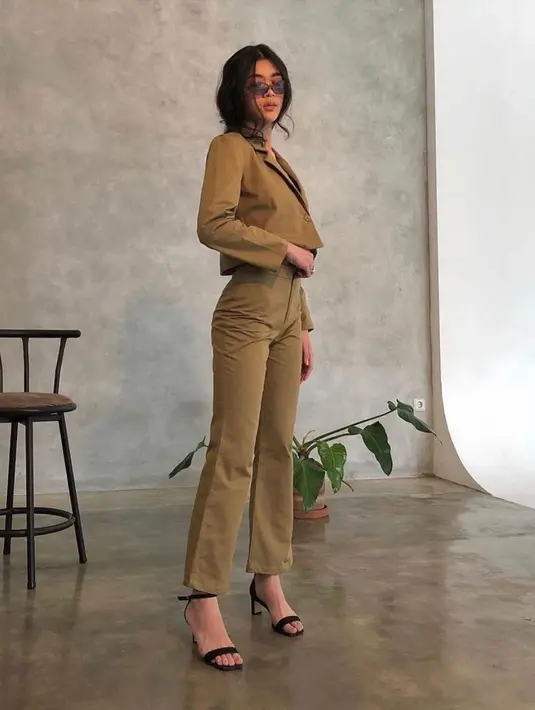 Kali ini dibalut workwear, Kayra tampil untuk photoshoot sebuah brand. Riasan wajah yang lagi-lagi tak mencolok, tapi tetap berhasil membuatnya tampil memesona, rambut Kayra ditata messy bergelombang. Ia mengenakan setelan atasan cropped blazer dan celana panjang berwarna hijau olive, yang serasi. Foto: Instagram.