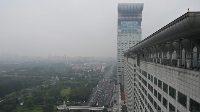 Gedung pencakar langit Pangu Plaza yang mendominasi daerah di seberang Stadion Olimpiade Bird's Nest, pusat kota Beijing, Selasa (20/7/2019). Bangunan 40 lantai hasil sitaan terkait kasus korupsi itu terjual dalam lelang online dengan harga 734 juta USD atau sekitar Rp10,5 triliun. (GREG BAKER/AFP)