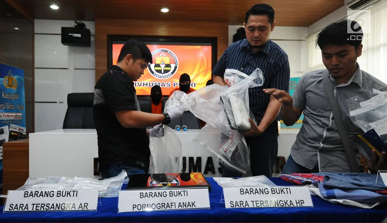 Petugas membongkar barang bukti kejahatan melalui internet saat rilis di Mabes Polri, Jakarta, Selasa (30/5). Petugas menahan enam tersangka dari empat kasus berbeda. (Liputan6.com/Helmi Fithriansyah)